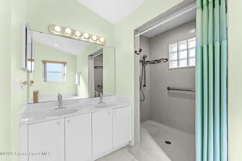a bathroom with a shower sink and mirror