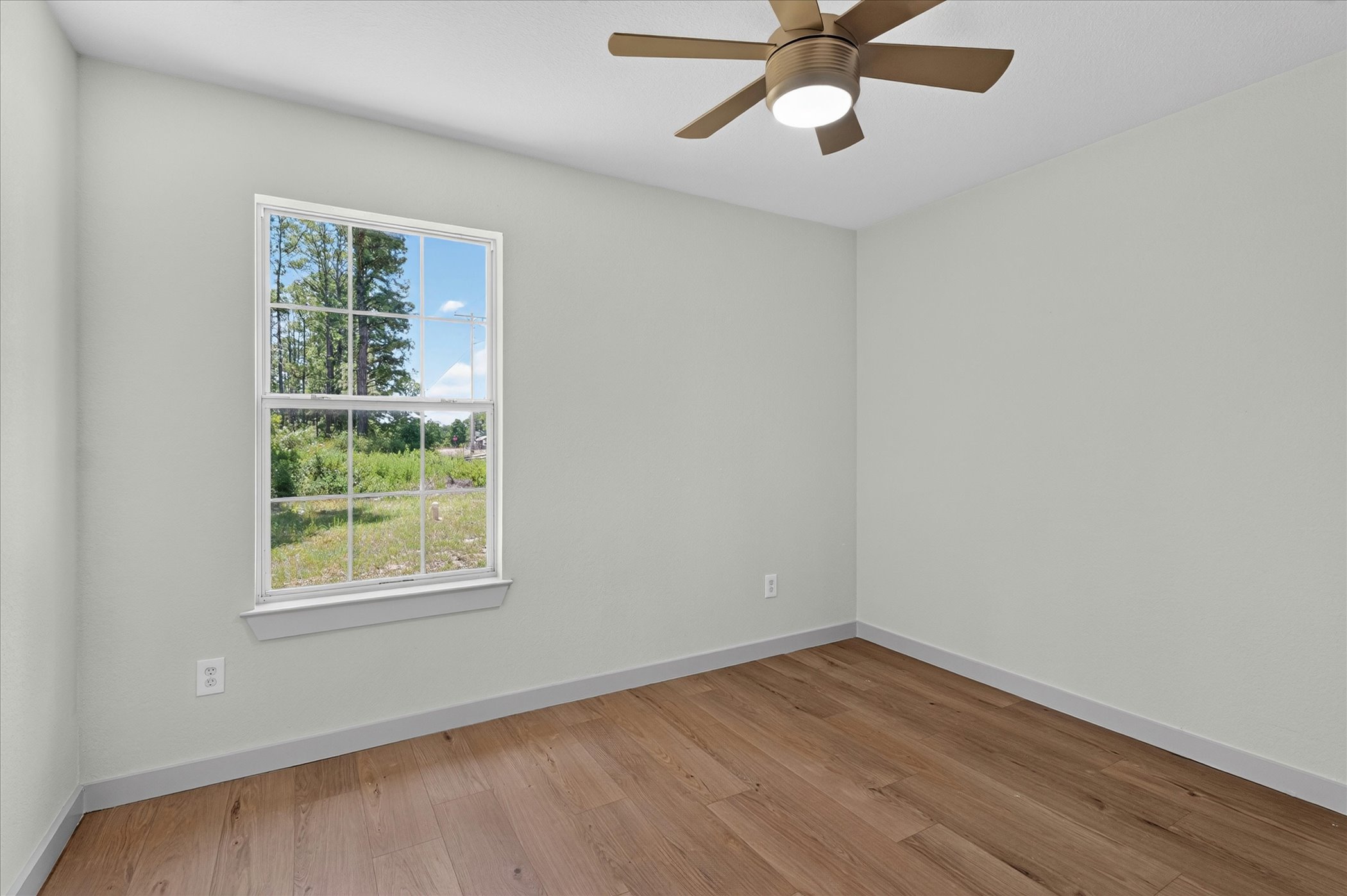 258 Pine View Loop Bastrop, TX 78602 - Photo 33 of 40 Well-lit interior space featuring broad plank flooring and an overhead ceiling fan.