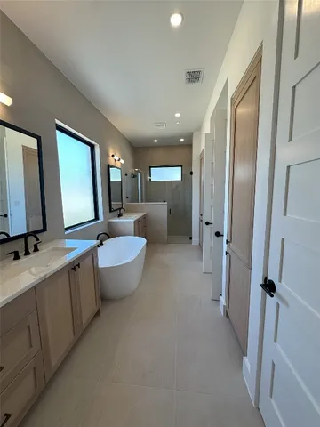 a bathroom with a double vanity sink toilet mirror and bathtub