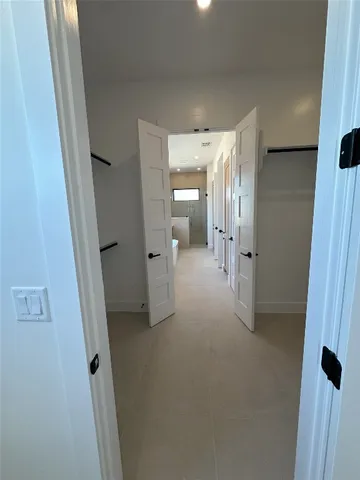 a view of a hallway with wooden shelves