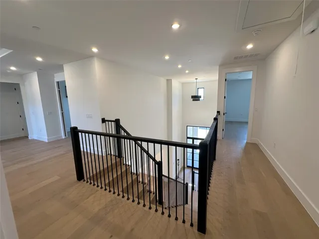 a view of empty room with wooden floor and ceiling fan