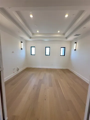 an empty room with windows and ceiling fan view