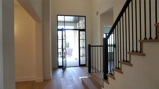 an entryway with wooden floor and stairs