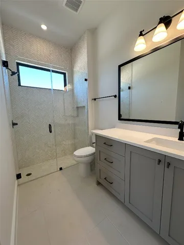 a bathroom with a double vanity sink toilet and shower