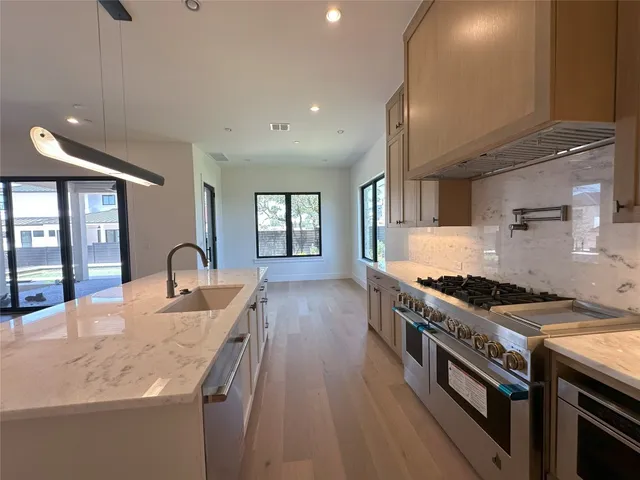 a kitchen with granite countertop a stove and a sink