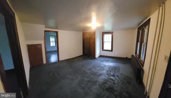 an empty room with windows and closet