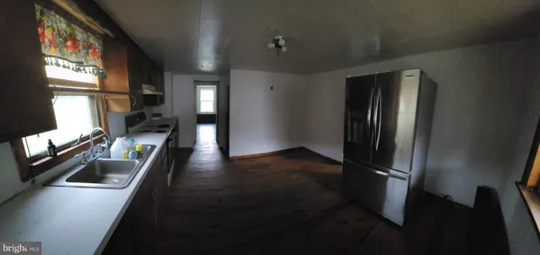 a view of a refrigerator in kitchen and a window