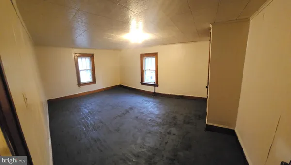 an empty room with windows and closet