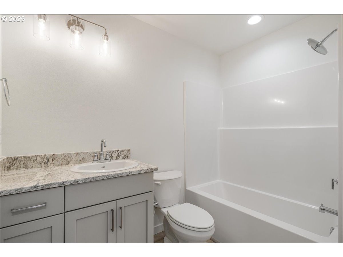 357 Southeast Kitzmiller Drive Dallas, OR 97338 - Photo 6 of 8 a bathroom with a granite countertop sink a toilet and bathtub