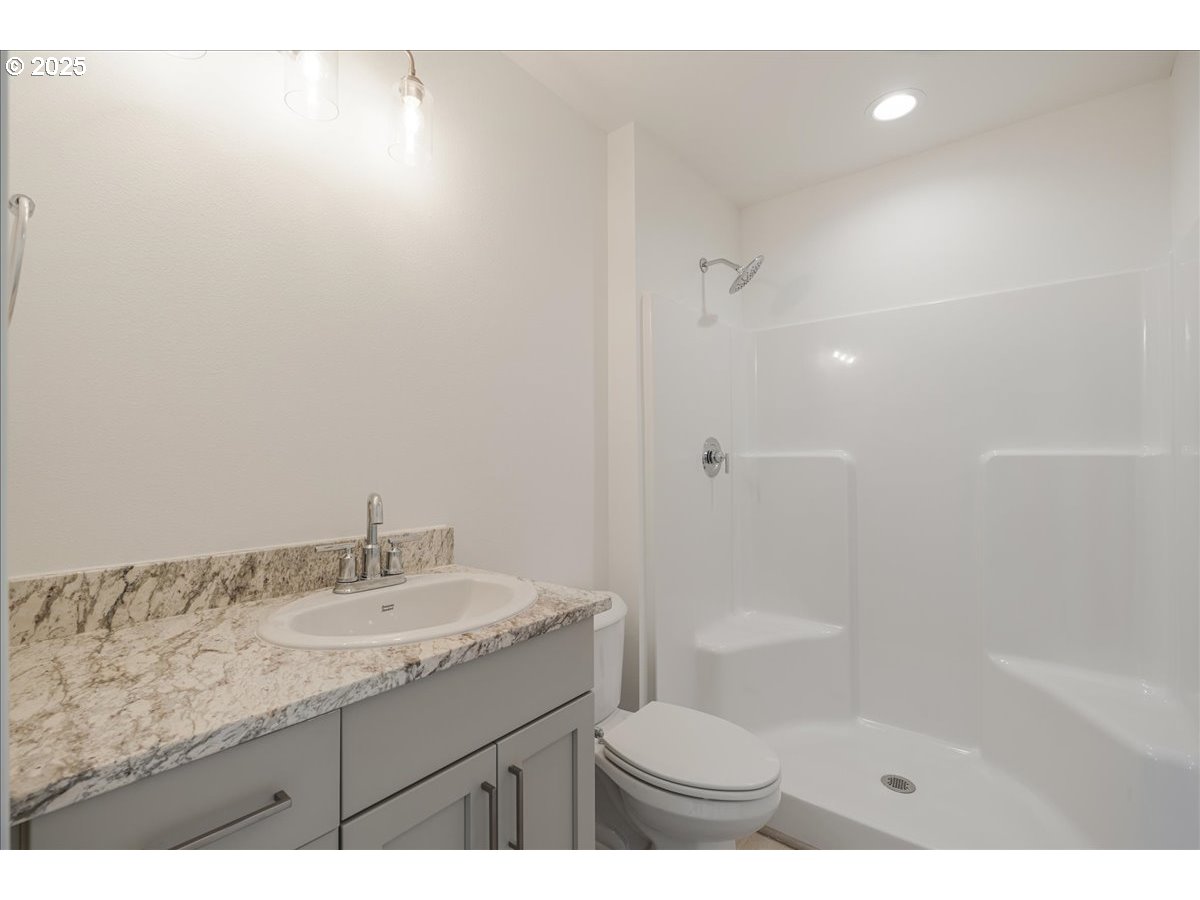 357 Southeast Kitzmiller Drive Dallas, OR 97338 - Photo 8 of 8 a bathroom with a granite countertop sink a toilet and shower