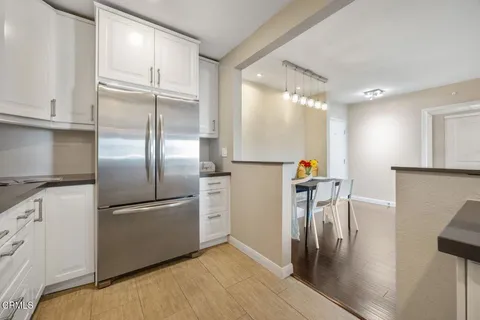 a kitchen with stainless steel appliances granite countertop a refrigerator and a stove top oven