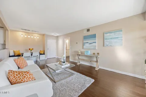 a living room with furniture and a wooden floor