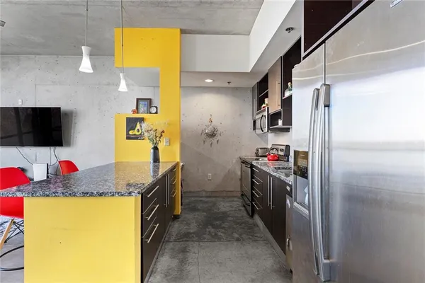 a kitchen with stainless steel appliances granite countertop a sink and a refrigerator