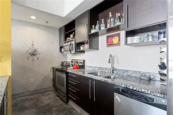 a kitchen with stainless steel appliances granite countertop a sink and a stove