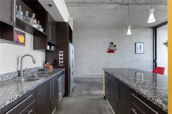 a kitchen with granite countertop a sink a stove and cabinets