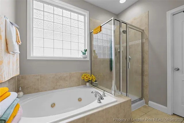 a bathroom with a tub shower and mirror
