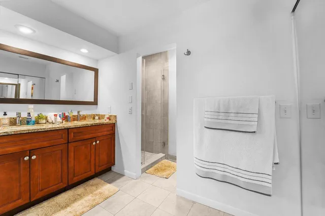 a spacious bathroom with a granite countertop sink and a mirror