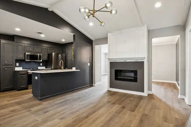 a kitchen with stainless steel appliances kitchen island granite countertop a stove top oven and sink