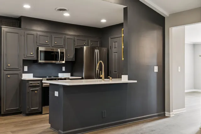 a kitchen with stainless steel appliances granite countertop a stove a sink and a refrigerator