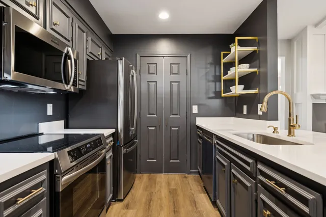 a kitchen with stainless steel appliances granite countertop a sink and a stove