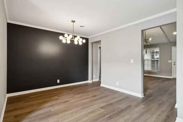 an empty room with wooden floor and mirror