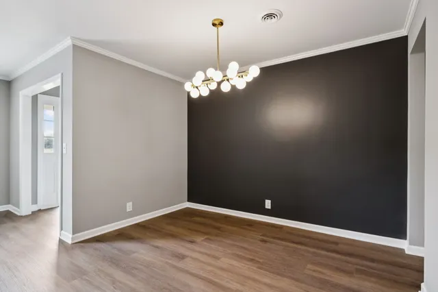a view of a room with wooden floor and chandelier