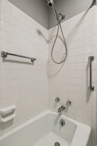 a bathroom with a bath tub with a shower