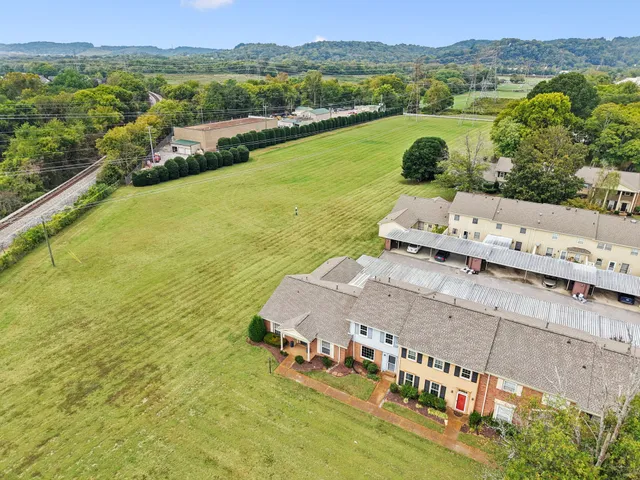 an aerial view of residential houses with outdoor space and river