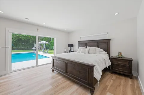 a bed sitting in a spacious bedroom next to a window