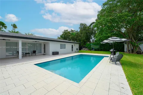 a swimming pool with outdoor seating and yard