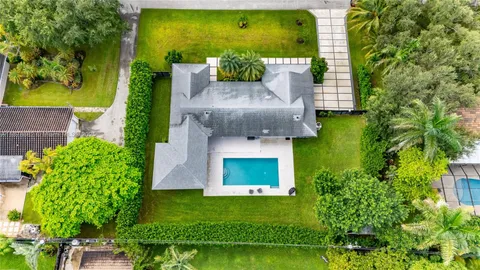 an aerial view of a house with a yard basket ball court and outdoor seating