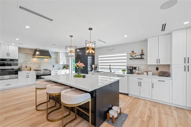 a kitchen with granite countertop a sink appliances cabinets and chair