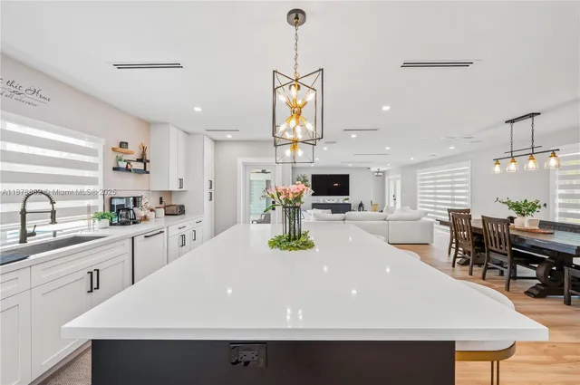 a kitchen with stainless steel appliances a kitchen island a stove a sink a dining table and chairs