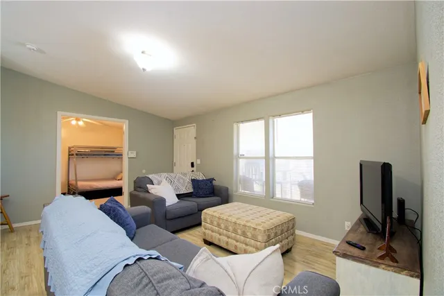 a living room with furniture and a dining table with wooden floor