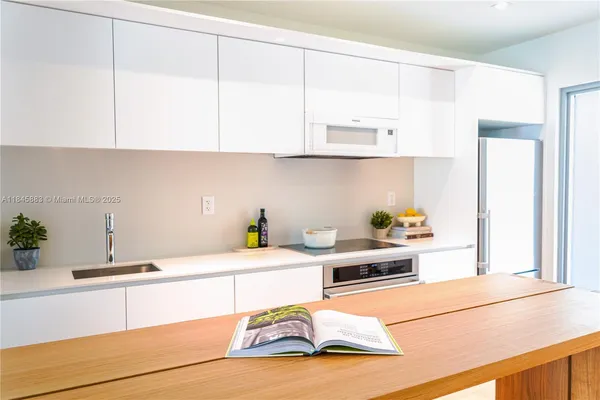 a kitchen with stainless steel appliances kitchen island granite countertop sink and cabinets