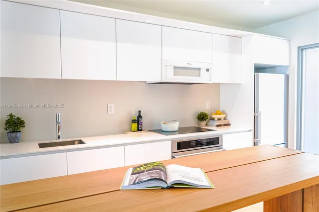 a kitchen with stainless steel appliances kitchen island granite countertop sink and cabinets