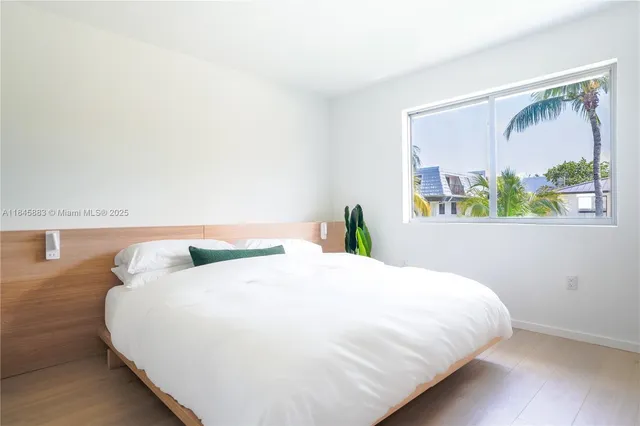 a bedroom with a bed window and mirror