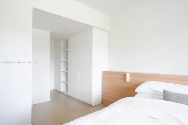 a bedroom with a bed and a night stand