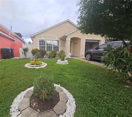 a view of a house with backyard sitting area and garden