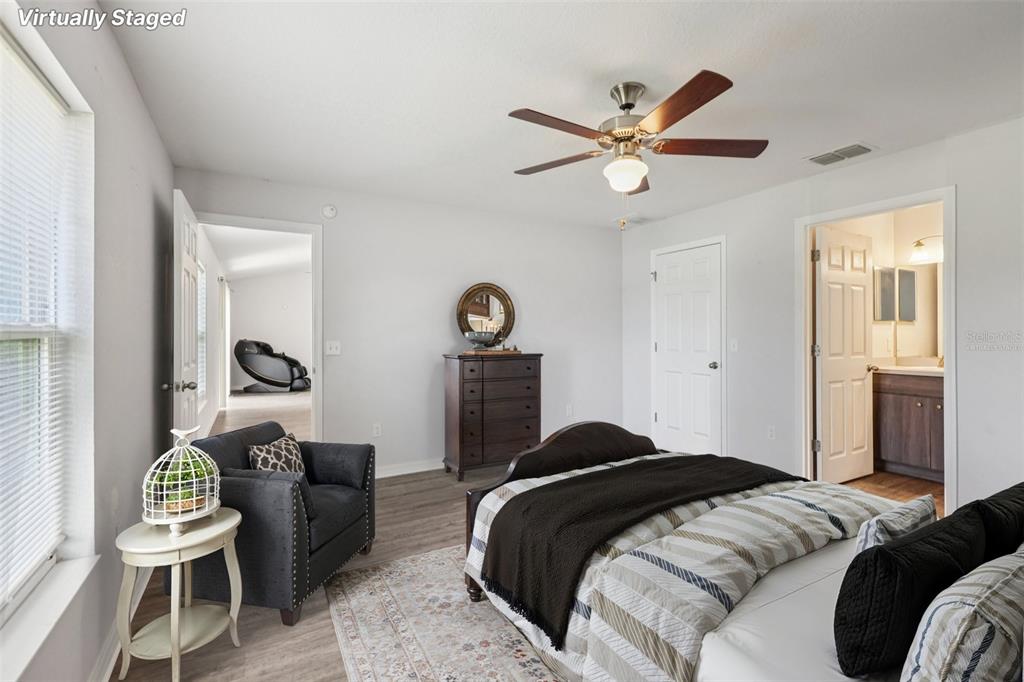 5 Laurel Pass Court Ocala, FL 34480 - Photo 11 of 23 a bedroom with a bed and a chandelier