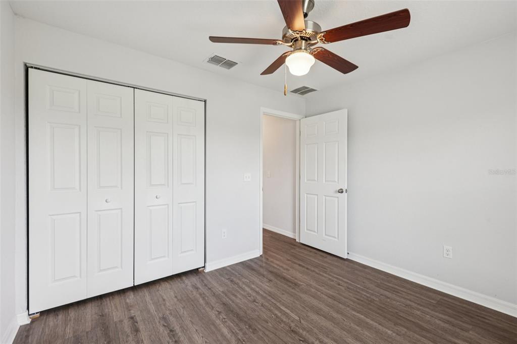 5 Laurel Pass Court Ocala, FL 34480 - Photo 19 of 23 an empty room with wooden floor fan and windows