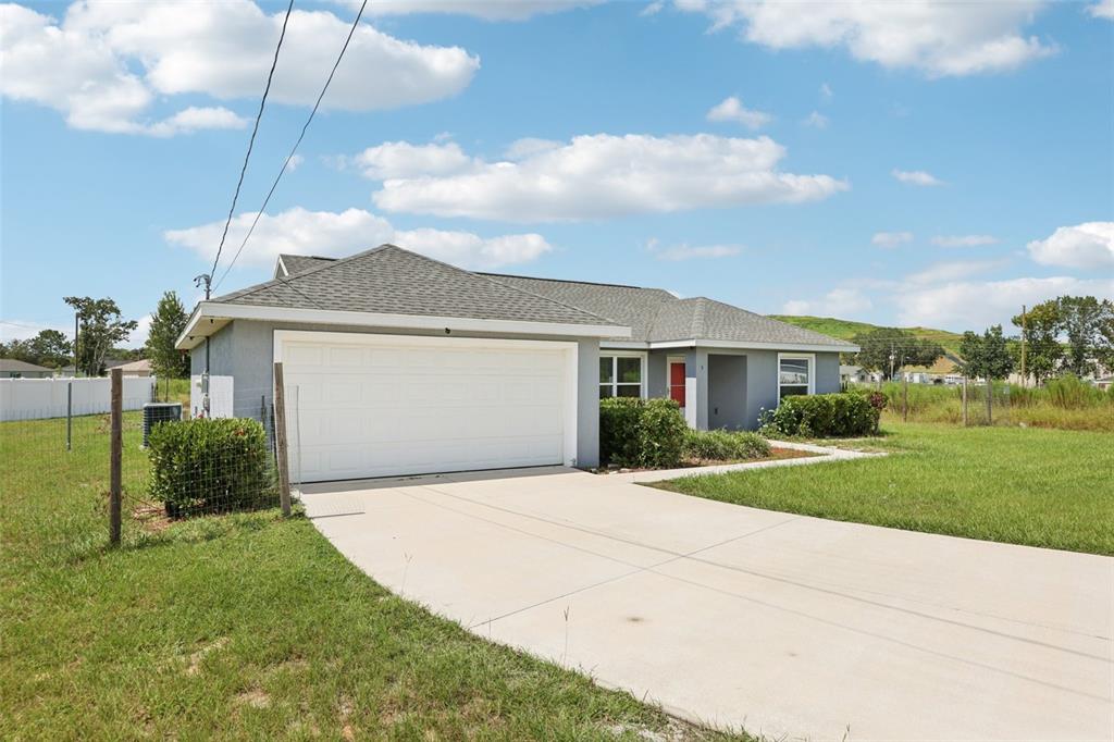 5 Laurel Pass Court Ocala, FL 34480 - Photo 2 of 23 a front view of a house with a yard and garage