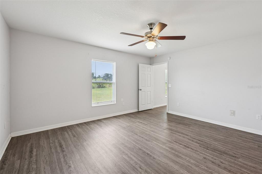 5 Laurel Pass Court Ocala, FL 34480 - Photo 10 of 23 an empty room with wooden floor fan and windows