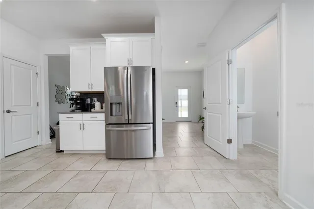 a living room with furniture a potted plant and kitchen view