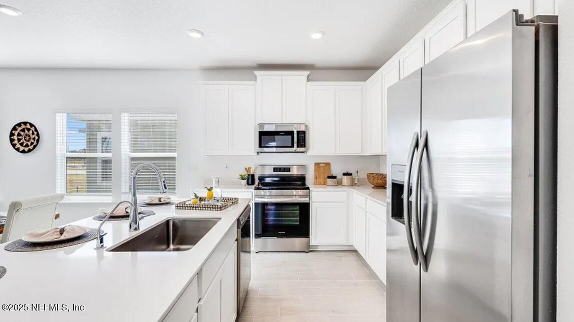 3199 Tupelo Loop Green Cove Springs, FL 32043 - Photo 16 of 26 a kitchen that has a refrigerator and a sink