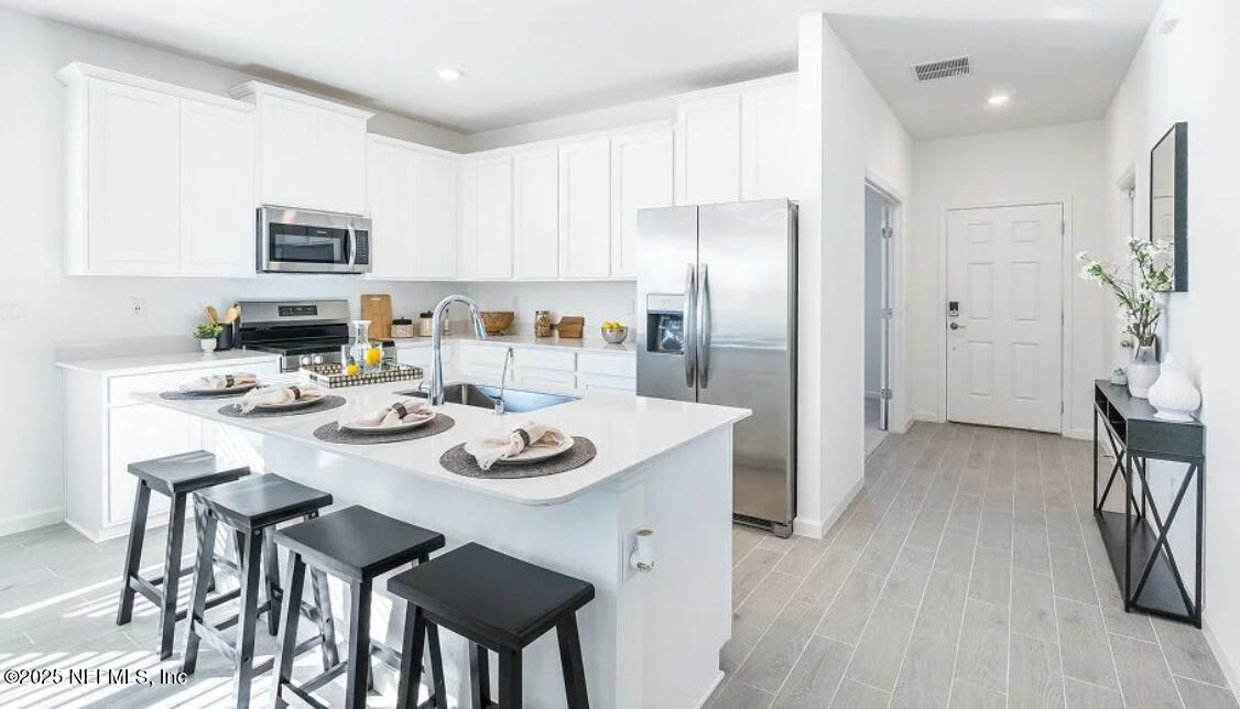 3199 Tupelo Loop Green Cove Springs, FL 32043 - Photo 17 of 26 a kitchen with stainless steel appliances granite countertop a dining table chairs and refrigerator