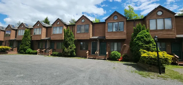 a view of a big house with many windows and a yard