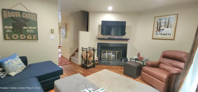 a living room with furniture a flat screen tv and a fireplace