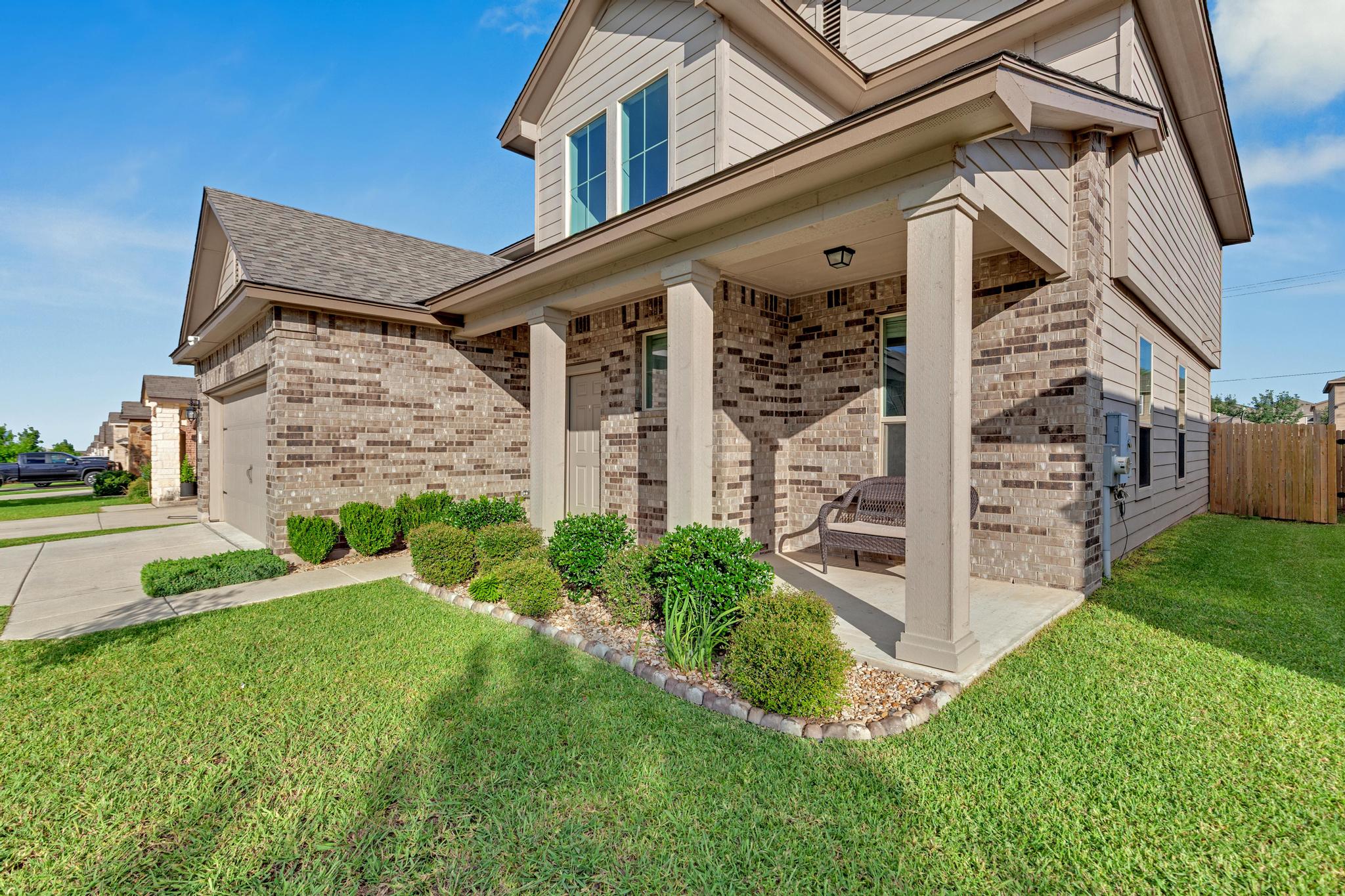 104 Uncle Billy Way Jarrell, TX 76537 - Photo 4 of 38 A welcoming front porch with manicured landscaping enhances this appealing brick and siding residence.
