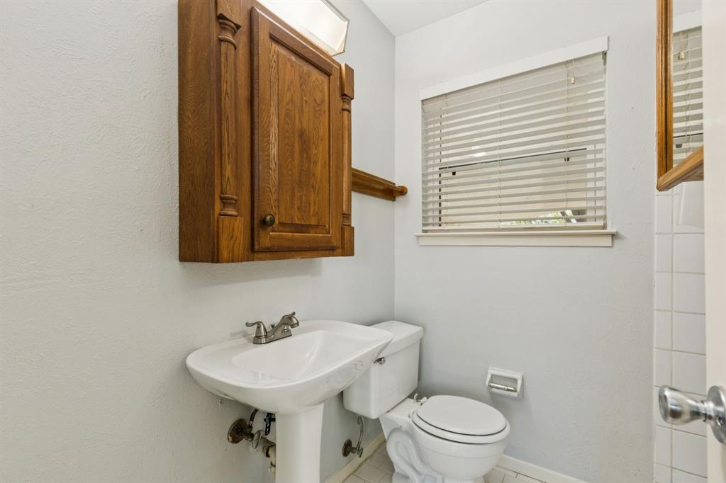 1602 England Road Arlington, TX 76013 - Photo 18 of 27 a bathroom with a toilet a sink and a mirror